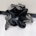 Elegante elastico in raso nero decorato con tre farfalle di strass argentati brillanti - Stile con tre fiocchi a farfalla in strass / Nero