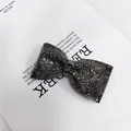 Makroaufnahme einer schwarzen Schleifen-Haarklammer mit glitzernden Strasssteinen auf Magazin - Einzelne Schleife Entenschnabel-Clip (Waffenschwarz Strass)