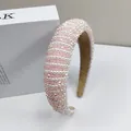 Dettaglio di cristalli rosa e perle bianche su una fascia per capelli ampia imbottita - Rosa