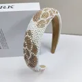 Detailed view of hand-beaded white and gold pearls on a padded velvet headband - Champagne Polka Dot