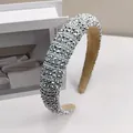 Nahaufnahme eines gepolsterten Haarreifs mit funkelnden Silbersteinen und Perlen - Silber Strass Stil