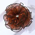 Macro d'une grande pince à cheveux fleur en organza orange avec centre en strass brillant - Café