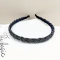 Detalle de diadema trenzada con cuentas negras con textura en espiral y acabado brillante - Azul marino