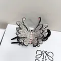 Dettaglio della molletta a farfalla per capelli con strass scintillanti su base nera - Strass Champagne