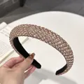 Detalle de una diadema acolchada de lujo adornada con brillantes cristales champán - Forma de V / Diamante Champaña