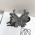 Dettaglio macro della lussuosa molletta a farfalla nera con strass scuri e scintillanti - Strass Nero Fucile