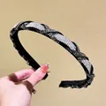 Close-up of twisted braided headband with sparkling crystals and black velvet lining - White and Mineral Gray Rhinestone