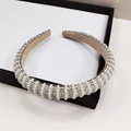 Vue détaillée du serre-tête avec perles, strass et doublure en daim beige - Style rayures verticales perles artificielles et strass blancs