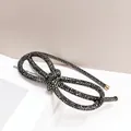 Macro detail of black rhinestone headband with fixed bow and elegant gold metal end caps - Mineral Grey Rhinestone