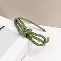 Macro shot of green rhinestone bow headband with elegant gold metal end caps detail - Green Zircon