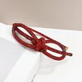 Detailed close-up of a red rhinestone knotted headband with premium gold metal ends - Red Rhinestone