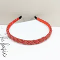 Detalle de diadema trenzada de cuentas rojas con textura brillante y puntas de tela - Rojo