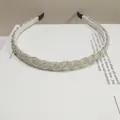Detalle de diadema trenzada plateada decorada con finas cuentas blancas y artesanales - Plata