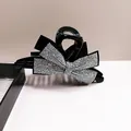 Grande pince à cheveux noire élégante avec nœud en strass brillants sur fond blanc - Coloré