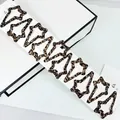 Set aus 10 sternförmigen Haarspangen mit Leopardenmuster auf einer Produktkarte - Leopard Sternform Stil