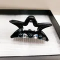 Detail der sternförmigen Haarklammer mit blauen Perlen, Herzsteinen und Metallschild - Schwarz