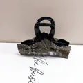Dettaglio ravvicinato di una pinza per capelli nera con fiocco di strass su sfondo neutro - Stile Piccolo Fiocco Interamente in Strass / Strass Grigio Trasparente