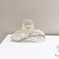 Dettaglio delle catene di strass e perle sulla pinza per capelli in resina champagne - Forma a 8 Trasparente