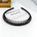 Diadema fina con estampado de leopardo y peine interior sobre fondo de libro blanco - Tela de Leopardo Envuelto Dentado / Leopardo Claro