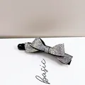 Détail de la pince banane en forme de nœud avec des strass irisés scintillants - Zircon AB