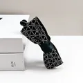 Elegante pinza de plátano con lazo negro y diamantes de imitación en caja blanca - Lazo calado con pedrería / Color gunmetal