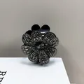 Detail van bloemvormige haarklem met grijze strasstenen en centraal kristal - Transparante Grijze Strass