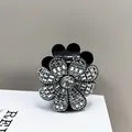 Gedetailleerde close-up van een luxe bloem haarclip met glanzende zilveren strasstenen - Witte Zirkoon