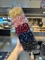Detalle de 5 coleteros de organza plisada en un conjunto dentro de una caja de plástico - Brillo Champaña/Rosa/Rojo/Azul/Negro (HC-31)