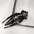 Detailed close-up of glossy black hair claw clip with sparkling rhinestone floral pattern - Claw Clip (Swallowtail Crystal)
