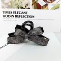 Pince à cheveux élégante avec nœud noir, strass argentés et finition brillante - Métal canon
