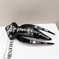 Close-up of black glossy hair clip with shimmering floral rhinestone patterns - Claw Clip (Swallowtail Crystal)