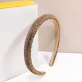 Detailed view of champagne gold crystal headband resting on an elegant gift box - Champagne