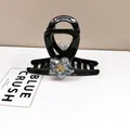 Detail of elegant black hair claw clip featuring a blue crystal flower with gold rhinestone - Medium Hair Claw / Blue Crystal