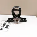 Close-up of black hair claw clip with sparkling crystal flower and elegant rhinestone inlay - Medium Hair Claw / Amethyst