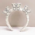 Close-up of handmade white pearl headband with elegant butterfly rhinestone details - Bride Party Butterfly Style / Pearl White