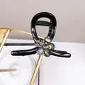 Elegant black resin hair claw with a grey crystal flower on a golden metal stand - Gray Crystal Flower Medium Claw Clip
