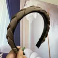Detailed view of brown braided satin headband with anti-slip teeth and comfortable tips - Light Coffee
