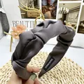 Detail van grijze satijnen hoofdband met knoop, handgemaakt label en plooistructuur - donkergrijs