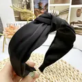 Detailed macro view of black satin headband featuring a chic twisted top knot design - Black