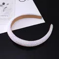 Sparkling crystal padded headband with colorful rhinestones on a glossy black surface - White