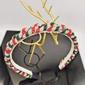 Makro-Detail des Weihnachts-Haarreifens mit roten und grünen Kristallen am Flechtband - Verdickter Geflochtener Stil