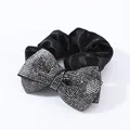 Detailed view of black satin scrunchie featuring a large sparkling rhinestone bow - Mineral Grey