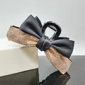 Details von eleganter Haarklammer mit schwarzer Schleife und glitzernden Strasssteinen - Champagnerfarbene Strasssteine