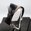 Detailed view of black satin headband with oversized bow and sparkling rhinestones - Black Satin Bow Headband with Champagne Rhinestones
