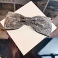Detail of elegant bow hair clip with shimmering rhinestones on white gift box - Gray
