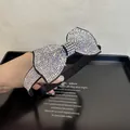 Close-up of a large black bow headband adorned with shimmering silver rhinestones - White