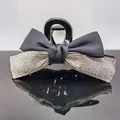Eleganter großer schwarzer Schleifen-Haarclip mit silbernen Strasssteinen auf Spiegel - Weißer Strass