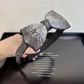 Gros plan de strass colorés étincelants sur un serre-tête à nœud noir élégant - Strass Gris Minéral