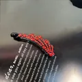 Vue détaillée d'une barrette banane de luxe avec cristaux rouges sur base noire brillante - Pince Banane Droite Avec Strass / 8cm / Rouge