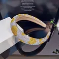 Diadema de esponja brillante con pedrería dorada y plateada sobre superficie de espejo - Estrás Amarillo y Blanco